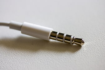 Close-up of white 3.5mm audio jack on textured surface