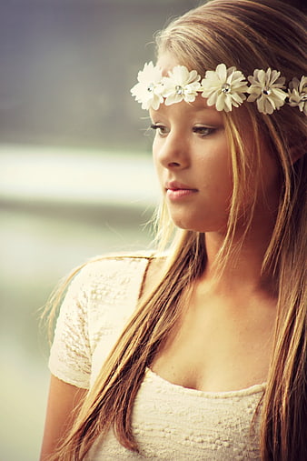 Young woman with white flower crown looking down