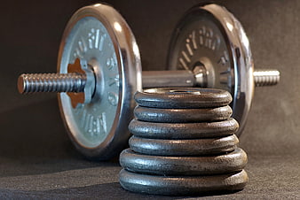 Stack of weight plates with barbell in background