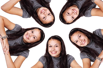 Five smiling young women in gray turtlenecks arranged in a circle