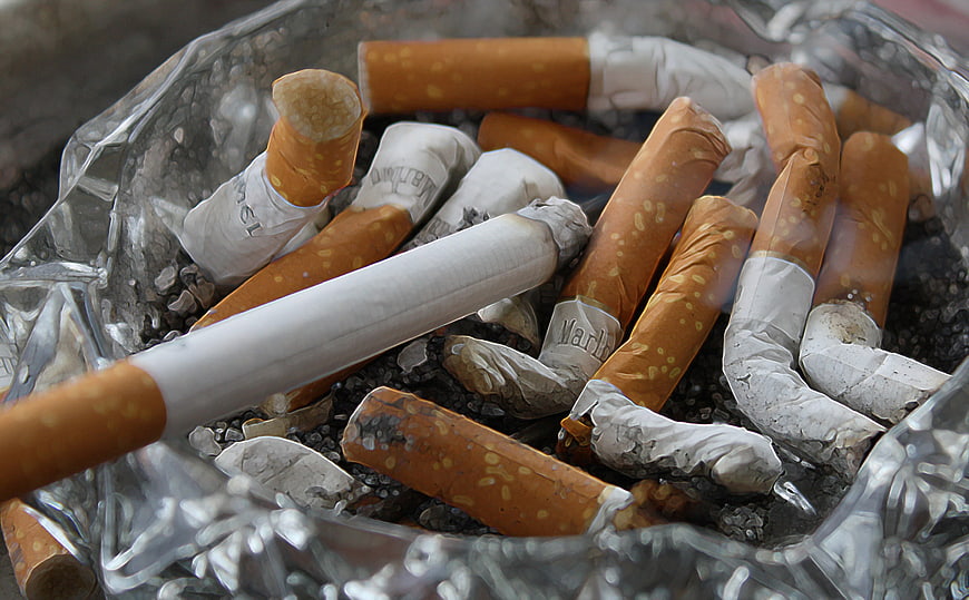 Close-up of cigarette butts in a glass ashtray