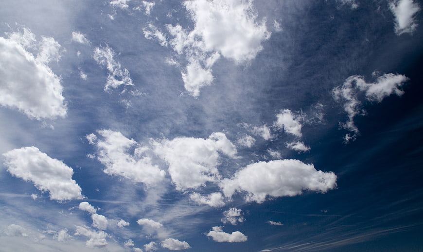 Dramatic blue sky with scattered white clouds