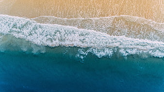 Aerial View of Ocean Waves Crashing on Sandy Beach