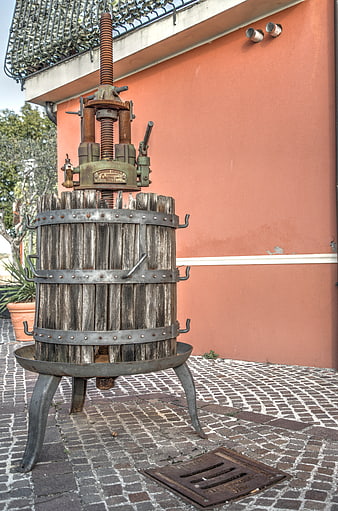 Vintage wooden wine press against terracotta wall