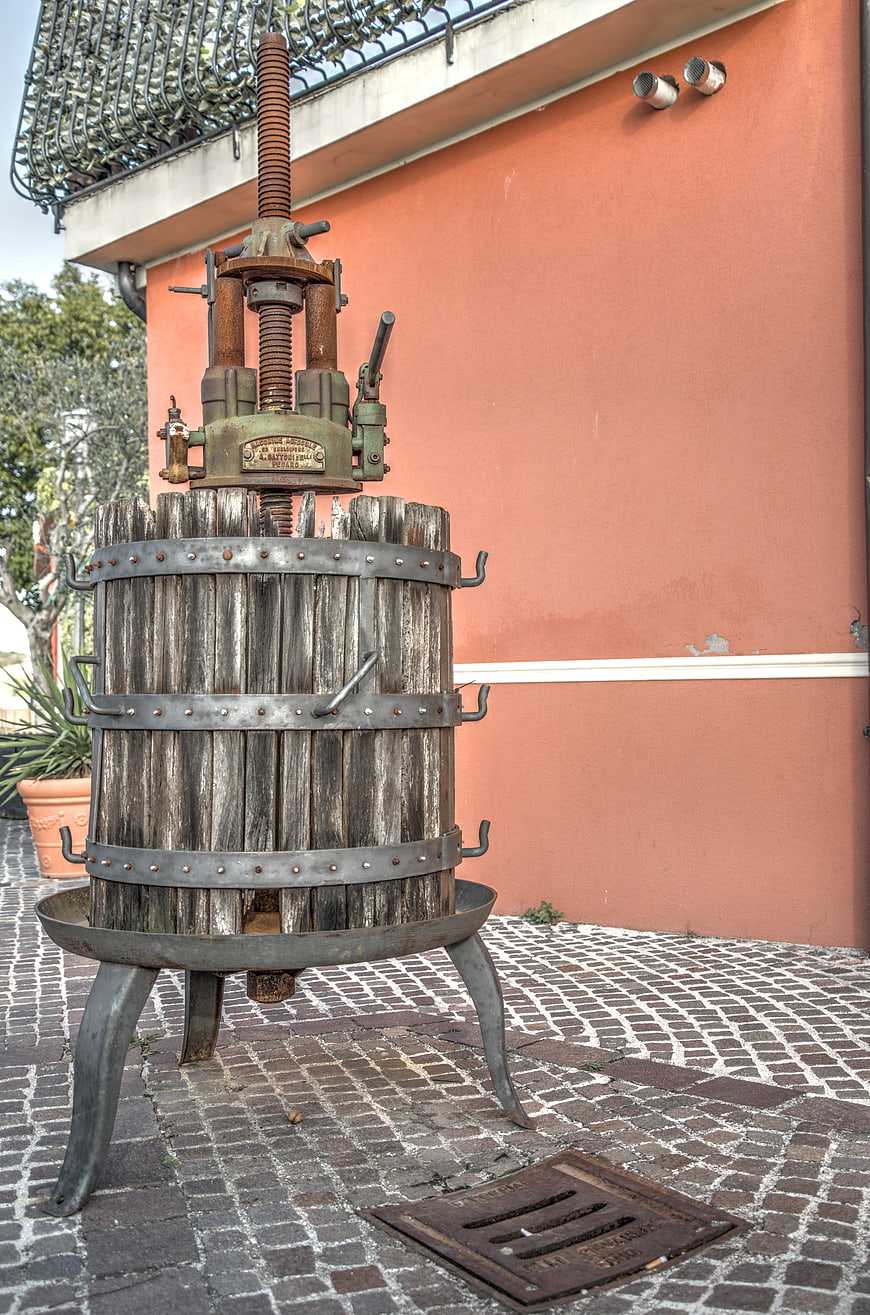 Vintage wooden wine press against terracotta wall