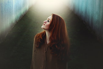 Redhead woman looking up in a misty tunnel