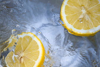 Fresh lemon slices splashing in clear water