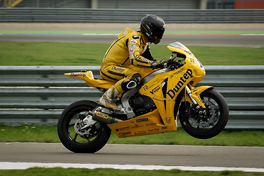 Yellow Racing Motorcycle Wheelie on Track