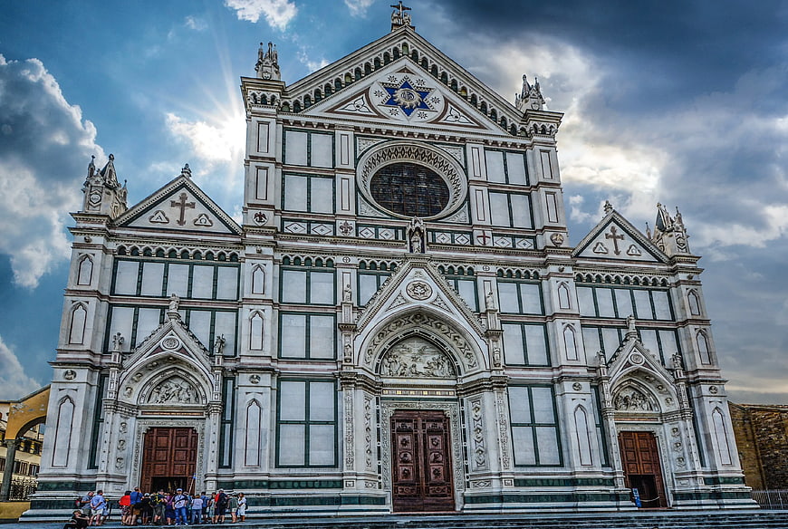 Orvieto Cathedral facade with dramatic sky and tourists