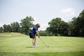 Senior Woman Golfer Addressing Ball on Green Course