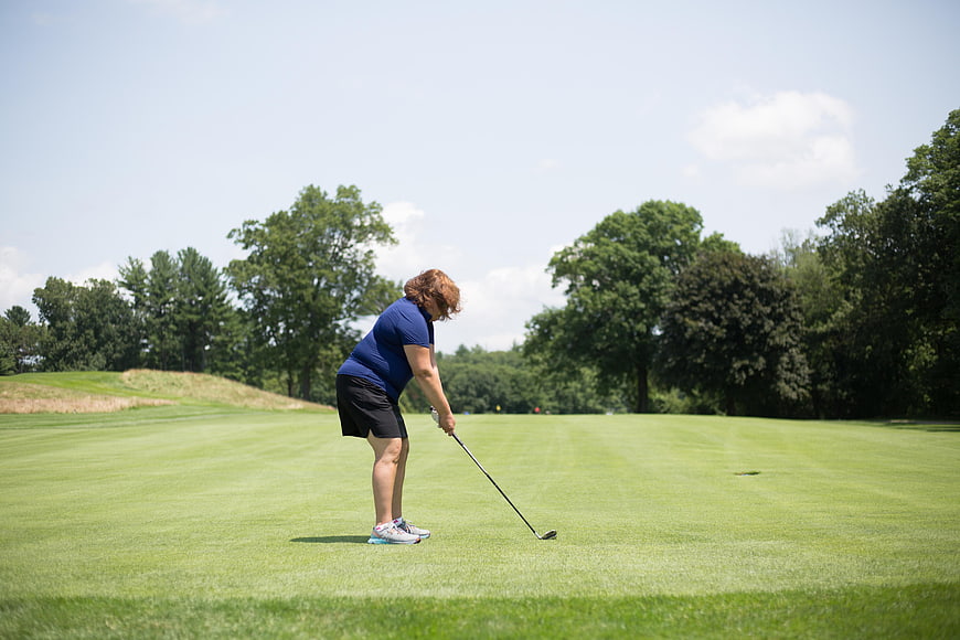 Senior Woman Golfer Addressing Ball on Green Course