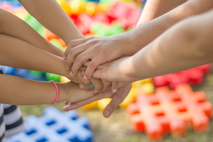 Children's Hands Stacked Together in Teamwork Gesture