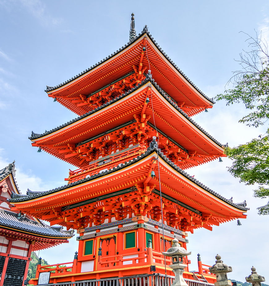Vibrant Orange Three-Story Pagoda Against Blue Sky