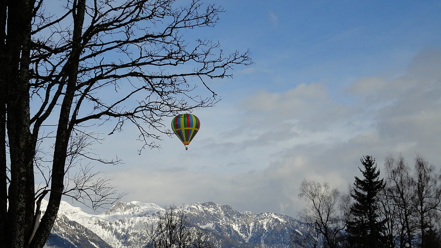 Colorful Hot Air Balloon Flying Over Snowy Mountains
