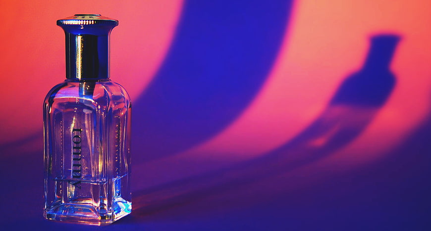 Tommy perfume bottle with dramatic pink and blue lighting