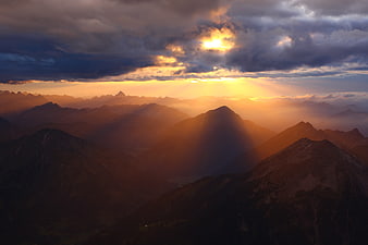 Dramatic Sunset Over Mountain Range with Sun Rays