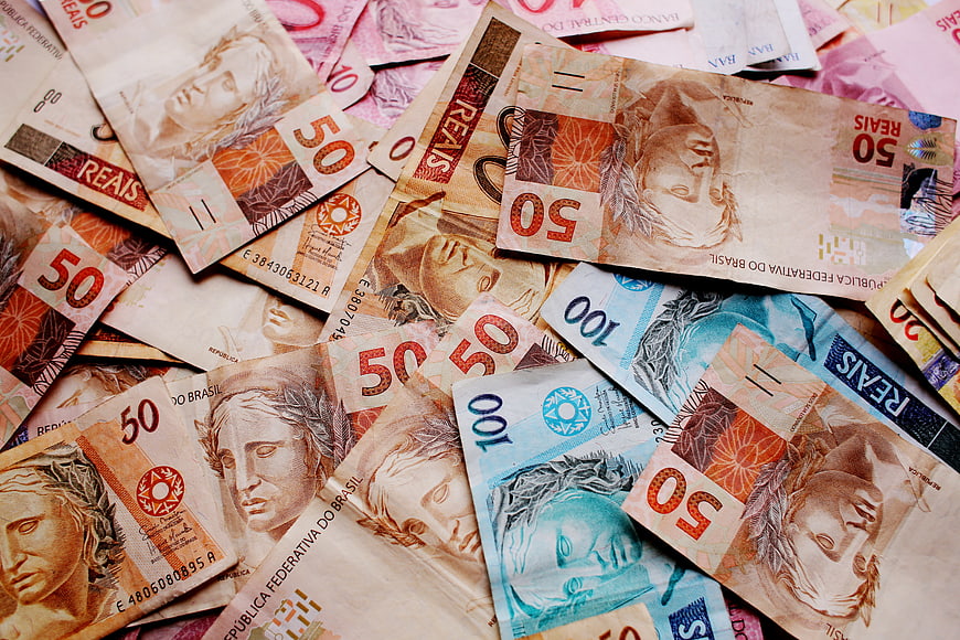 Scattered Brazilian Real banknotes in various denominations