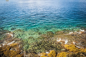 Aerial View of Turquoise Sea Over Rocky Coastline
