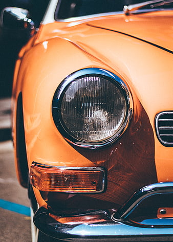 Close-up of vintage orange car headlight and bumper