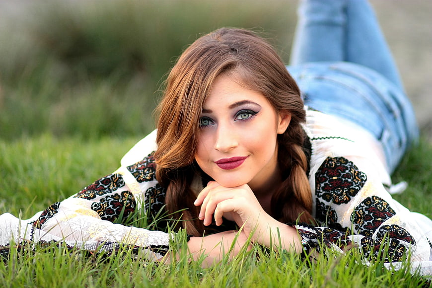 Young Woman Lying on Grass in Embroidered Blouse