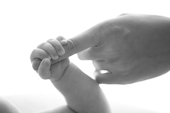 Baby Hand Holding Adult Finger Black and White Close Up
