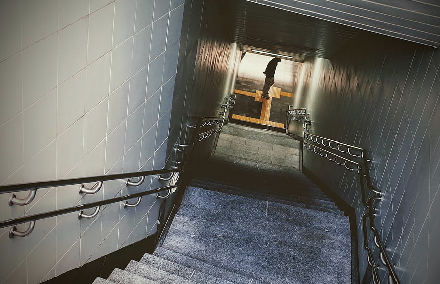 Man walking up subway stairs in urban tunnel