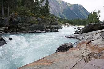 Rushing turquoise glacial river flowing through rocky mountain landscape