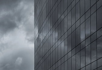 Modern Glass Building Facade Reflecting Stormy Clouds