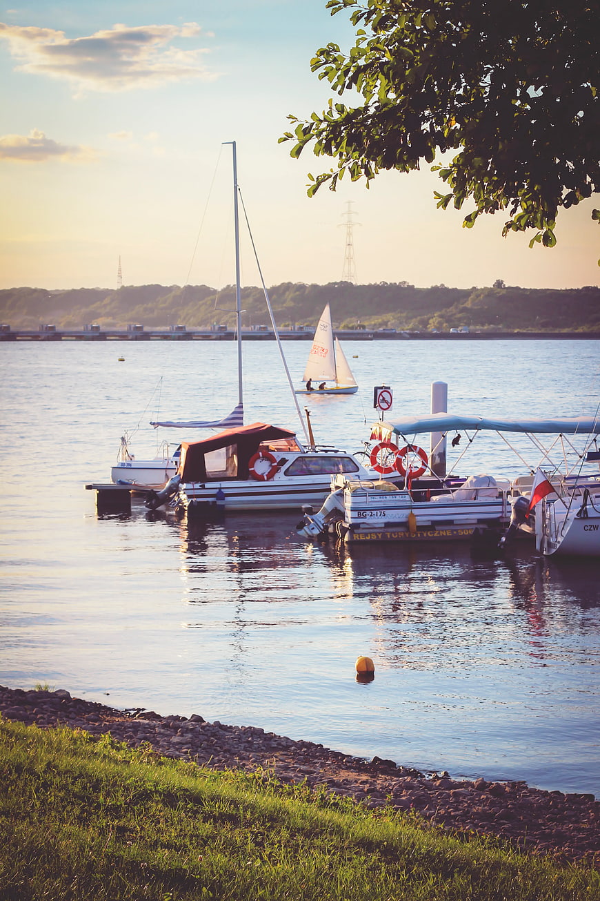 Boats docked at marina during golden hour sunset