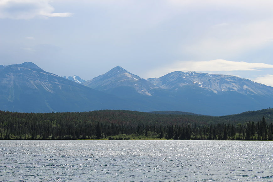 Scenic view of snow-capped mountains and forest across a lake