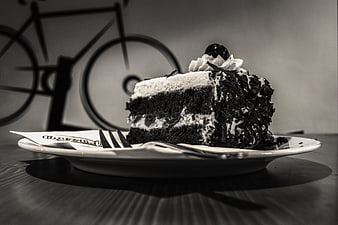 Black and white slice of chocolate cake with whipped cream