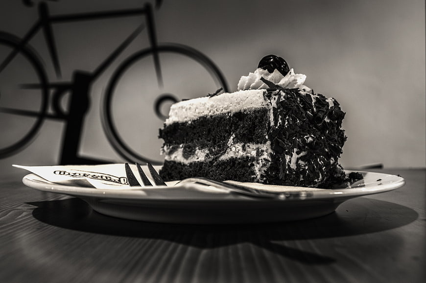 Black and white slice of chocolate cake with whipped cream
