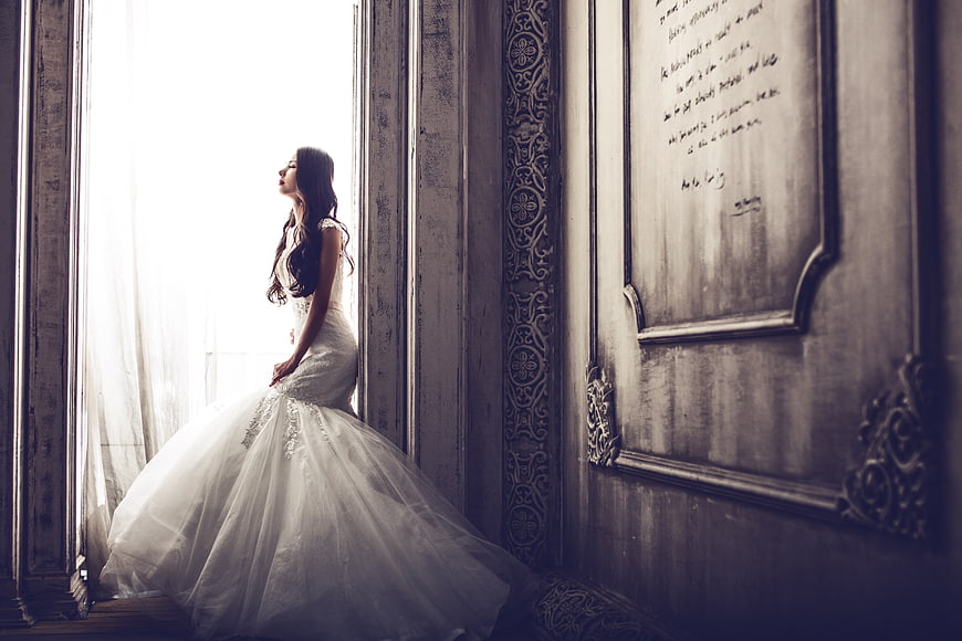 Elegant Bride in White Gown by Vintage Window