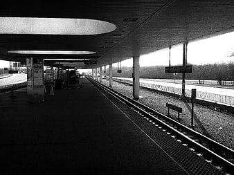Black and white photo of empty train station platform