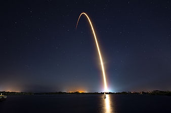 Long Exposure Rocket Launch Trail Over Water at Night