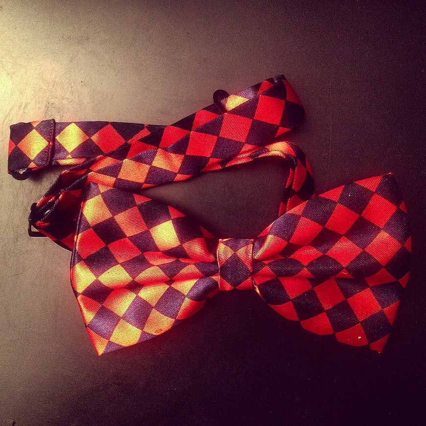 Red and Black Checkered Bow Tie on Dark Surface