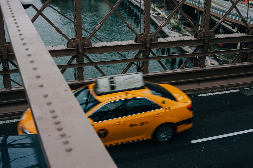Yellow Taxi Driving on Steel Bridge