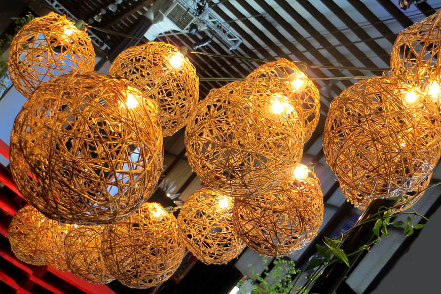 Cluster of glowing woven rattan sphere pendant lights