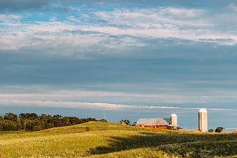 Red Barn and Silos on Rolling Green Hill Landscape