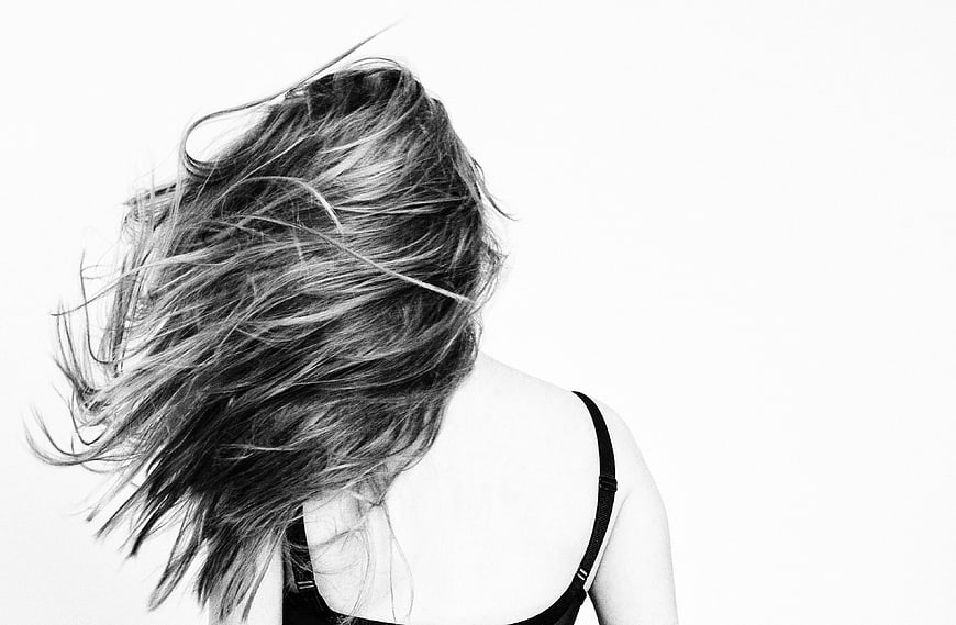Black and white portrait of woman with windblown hair