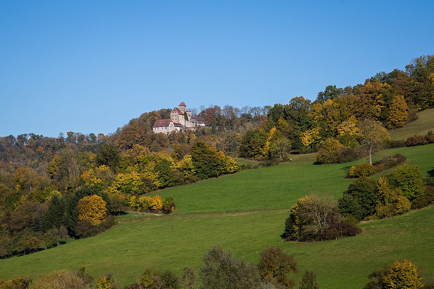 Castle on Hill in Autumn Landscape with Green Fields