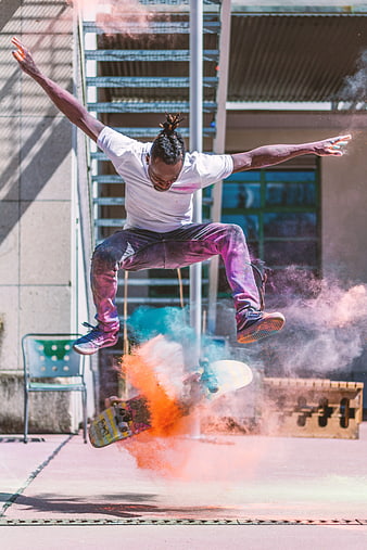 Skateboarder Jumping with Colorful Powder Explosion