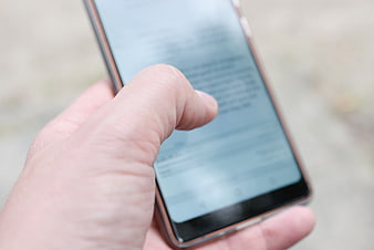 Close-up of hand using smartphone outdoors