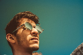 Man with Sunglasses Looking Up at Blue Sky
