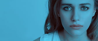 Close-up portrait of a woman with intense blue lighting and sad expression