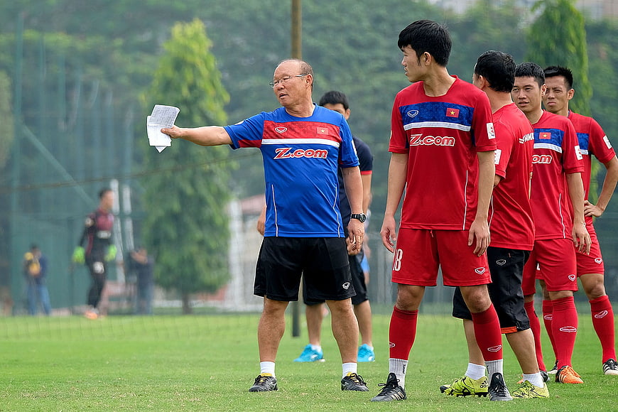 Football coach instructing players during training session