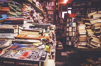 Stacks of books in a cozy, cluttered vintage bookstore aisle