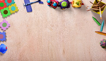 Colorful Children's Toys and Art Supplies on Light Wooden Background