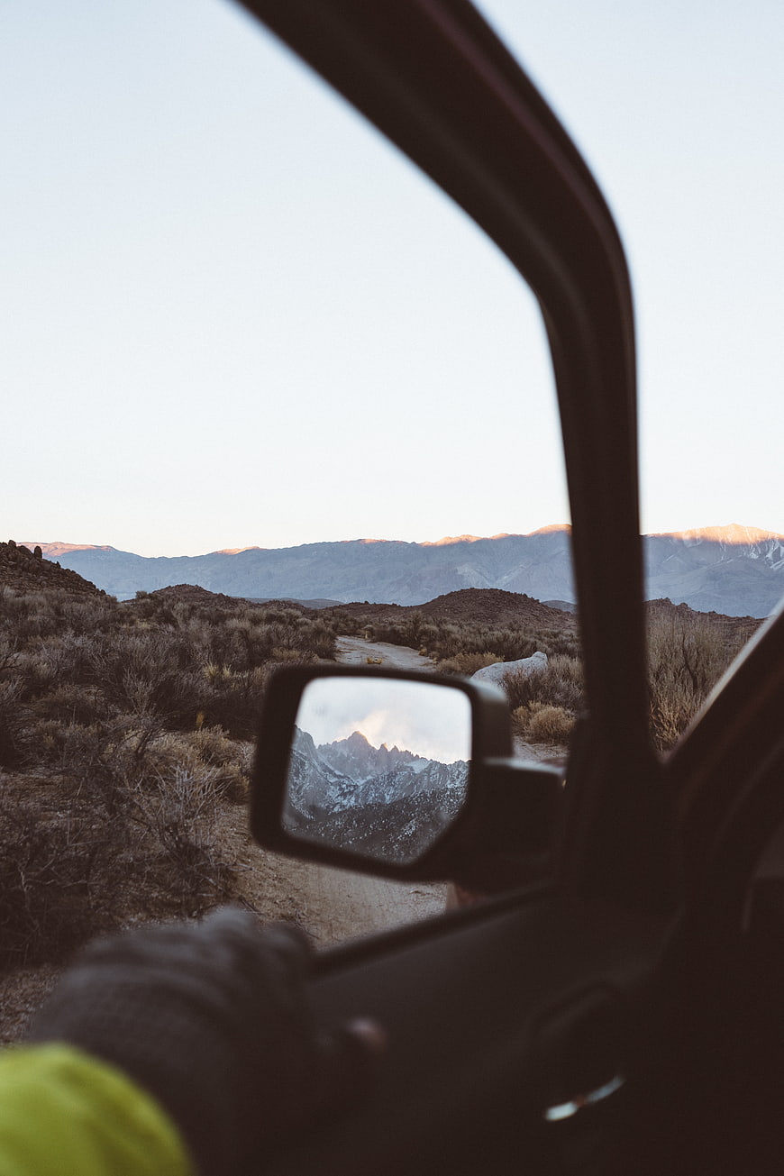 View from car window of desert mountains at sunset