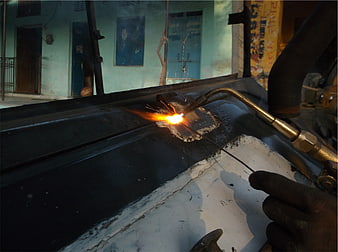 Close-up of manual metal welding with torch and sparks